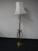 An early 20th century ornate brass rise and fall standard lamp