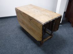 An oak pie crust edge drop leaf dining table