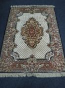 A fringed machine made woollen rug