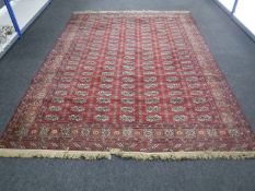 A fringed machine made Persian carpet on red round