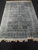 A machine made fringed Persian rug on turquoise ground