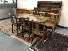 An early 20th century carved oak dining room suite comprising of sideboard,