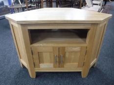 A contemporary oak corner TV stand