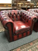 A Burgundy leather Chesterfield style buttoned club armchair,