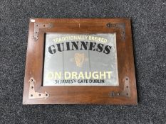A mahogany framed mirror with copper mounts bearing Guinness advertising