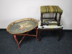 A hand painted gilt wood tray on stand together with two stools