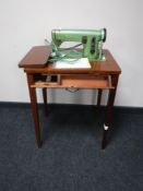 A mid twentieth century Husqvarna electric sewing machine in mahogany table