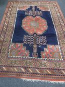 A large fringed woollen carpet of geometric design on red ground