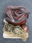 A vintage lawn bowls bag containing five composite lawn bowls and two wooden lawn bowls