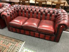 A Burgundy leather Chesterfield style buttoned three seater settee,