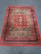 A machine made Persian carpet on red ground