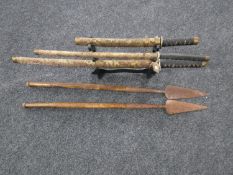 A set of three graduated samurai style swords on stands,