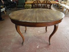 An early twentieth century mahogany extending oval dining table on cabriole legs