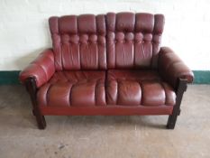 A twentieth century wood framed red button leather two seater settee
