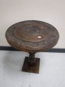 A carved Eastern hardwood occasional table on pine base