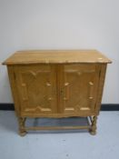 A blonde oak double door cabinet