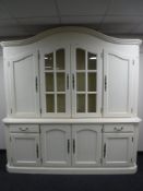 A painted arch topped four door display unit fitted with cupboards and drawers beneath