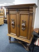 An early twentieth century oak double door cabinet carved with fruit,