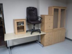 A contemporary office desk with high back swivel armchair a pine effect bookcase,