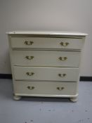 An antique pine painted four drawer chest on bun feet