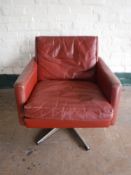 A twentieth century Danish red leather armchair on five way chrome support