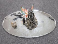 An oval unframed mirror,