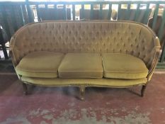 A salon settee upholstered in a gold button fabric