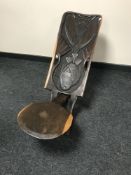 A carved African birthing chair