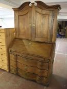 A nineteenth century oak serpentine fronted bureau bookcase
