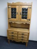 A blonde oak double door cabinet