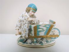 A continental porcelain figure of a man seated on a wheelbarrow