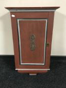 A painted single door wall cabinet
