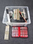 A box of various kitchen utencils and cutlery