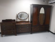 A three piece Victorian inlaid mahogany bedroom suite comprising of mirror door wardrobe,