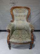 A Victorian mahogany gentleman's armchair upholstered in a floral button fabric