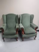 A pair of green dralon wingback armchairs