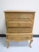 A blonde oak four drawer chest