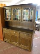 A continental oak triple door kitchen dresser with colour leaded glass doors