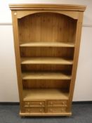 A pine bookcase fitted with four drawers,