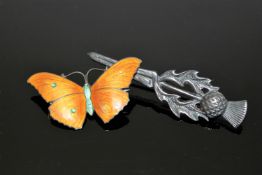 A silver and enamel butterfly brooch together with a Scottish silver thistle brooch