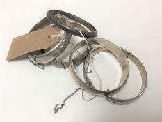 Five antique and later silver bangles.