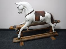 An antique hand painted rocking horse with leather saddle on pine stand CONDITION
