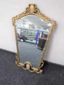 An ornate gilt framed mirror with enamelled panel