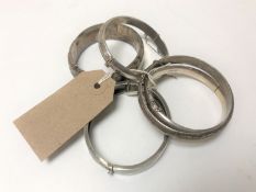 Five antique and later silver bangles.