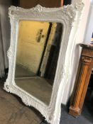 A highly ornate Victorian style white framed mirror
