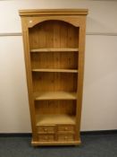 A pine bookcase fitted with four drawers,