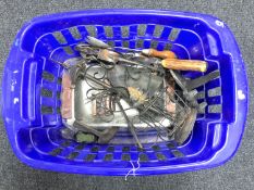 A basket containing assorted metal ware, including companion set, trivet, cutlery, carving set,