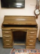 An early 20th century oak roll top desk,