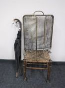 A brass fire guard, together with a rush seated stool,
