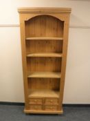 A pine bookcase fitted with four drawers,